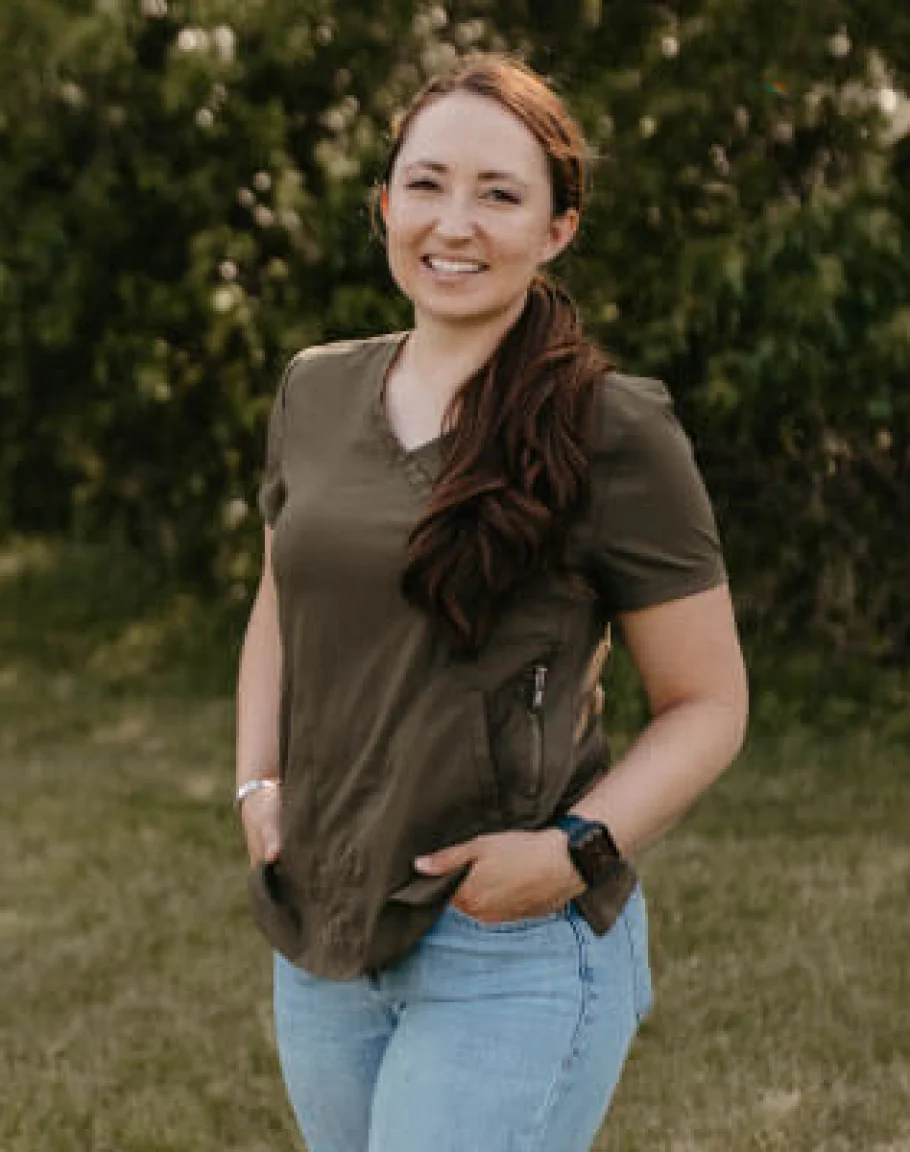 Dr. Ashley Silvey smiling outdoors in front of green trees